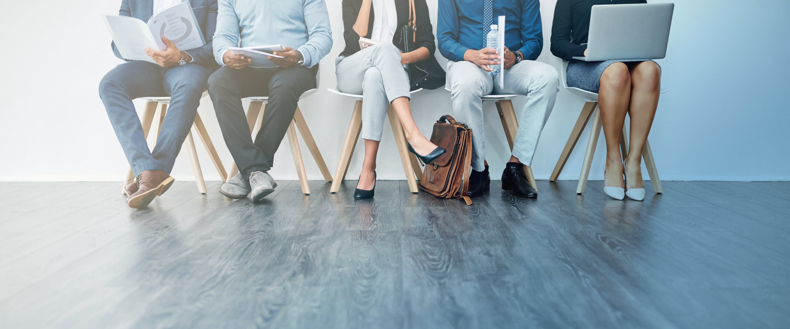 five individuals in professional attire sitting in a lobby